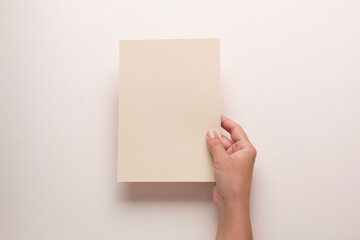 White booklet mockup. Female hands hold an empty blank. Blank form, mockup
