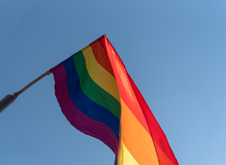 Bandera arco iris lgtbi ondeando al viento con el cielo de fondo