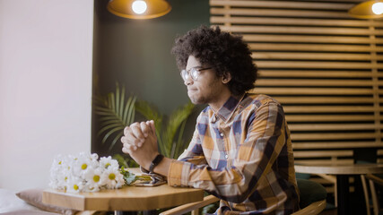 Young dissapointed man waiting in cafe, being stood up on a date, nobody's coming