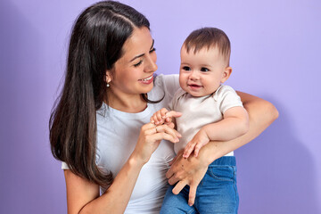 Woman mother in light clothes have fun with cute child baby girl, isolated on pastel purple wall background studio portrait Mother's Day love family parenthood childhood concept. Copy space
