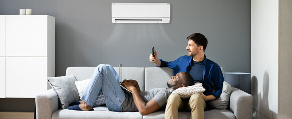 Gay Couple Holding Air Conditioner Remote