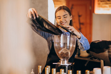 Female barista making coffee in a coffee machine
