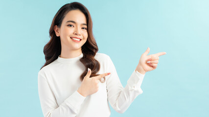 Happy beautiful young woman showing pointing to the side with fingers isolated on blue background.