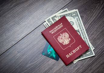 A foreign passport and dollars on a wooden background.