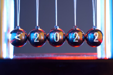 Newton's cradle on isolated gray with colorful lighting