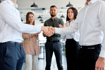 Fototapeta na wymiar two confident male entrepreneurs in formal clothes suit shaking hands after agreement, make contract. mutual business deal. Side view close-up hands. business people. colleagues clapping hands