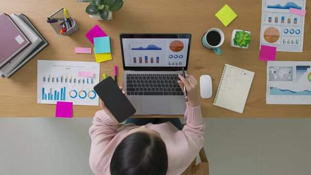 Above top desk of SME owner people home office call talk in SEO chart sale report paper or stock graph big data. Woman remote study MBA digital learn online of job career reskill upskill work plan.