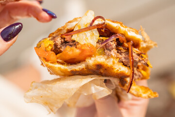 Close-up of a woman eating a burger. Bad eating habits