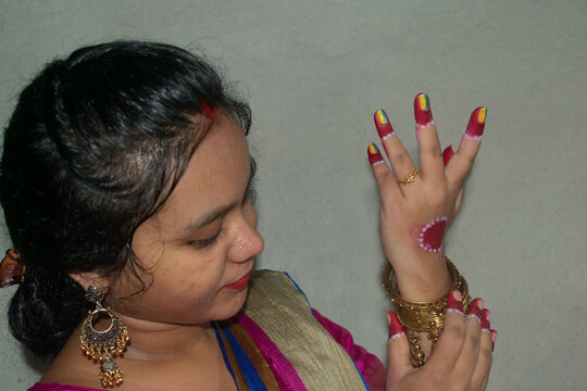 Portrait of an Indian woman wearing bangles on hand for a wedding or festival. Selective focus on the bracelets and fingers.