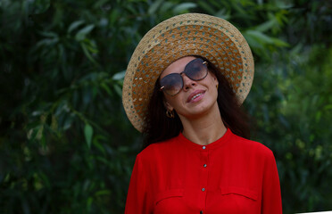 Portrait of an enthusiastic woman against a backdrop of green nature.