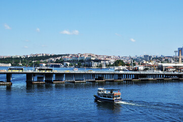 Fototapeta na wymiar Panoramic view of the bridge over the Golden Horn Bay. Bridge, pleasure ship and residential buildings of the city. 09 July 2021, Istanbul, Turkey.