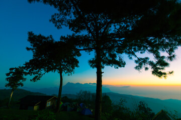 Obraz premium Colorful sky at the morning over mountains in north of Thailand with tents and house at top of mount
