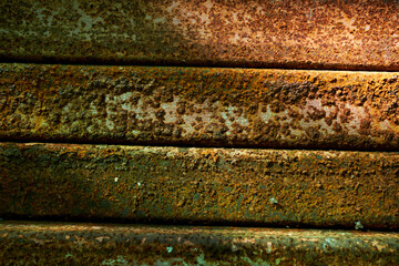 Close-up of cracked and peeling white paint on concrete wall. High detailed colorful rough wall texture background. Rusty and green construction material background concept