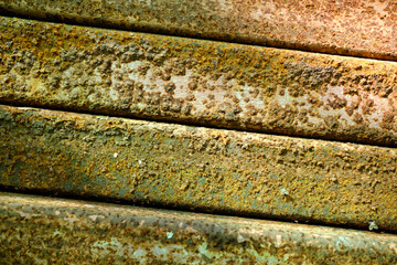 Close-up of cracked and peeling white paint on concrete wall. High detailed colorful rough wall texture background. Rusty and green construction material background concept