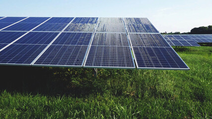 sunlight reflection close up on solar energy photovoltaic PV panels installed above the grass with nature background. - 452168833