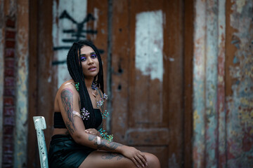 Portrait of a young beautiful tattooed girl with box braids hairstyle