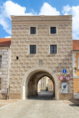 old tower like house with passage and sgraffito facades, a special carving technique in slavonice in the czech republic. Traffic signs show the exact dimensions of the passage.