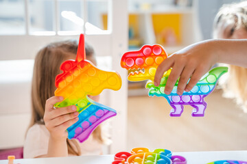 Little girls,kids,sisters play with colorful pop it children room,bedroom.Funny trendy silicone...