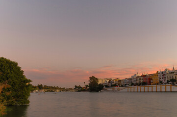 River and houses in the evening with colorful clouds | Seville, Spain