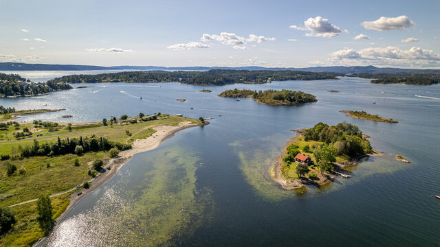 Fornebu beach in Oslo, Norway with fjords in the background and boats on the sea