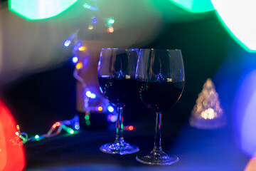 two wine glasses in a shining garland bokeh on a black background...