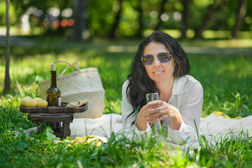 thoughtful woman sitting alone outdoors. elderly lady enjoying a summer day resting in the park.