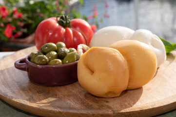 Cheese collection, Italian cheese scamorza made from cow milk in South of Italy served with green olives and red tomato