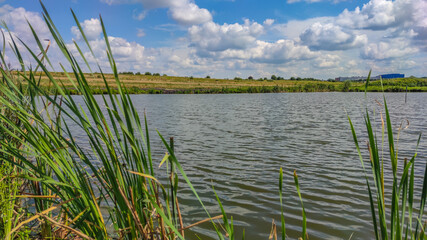 Fototapeta premium Landscape with a lake and clouds in the sky in the summer season