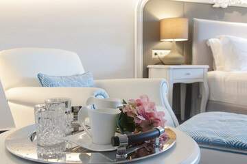 Tray with water glasses and coffee cups on the table in the bedroom