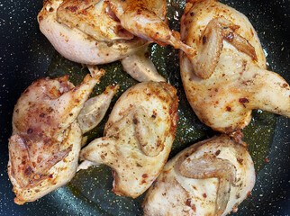 Quail carcasses fried in a frying pan in spices.