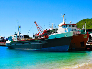 A tug and a cargo ship docked in Bequia, St Vincent and the Grenadines, Caribbean lesser Antilles.
