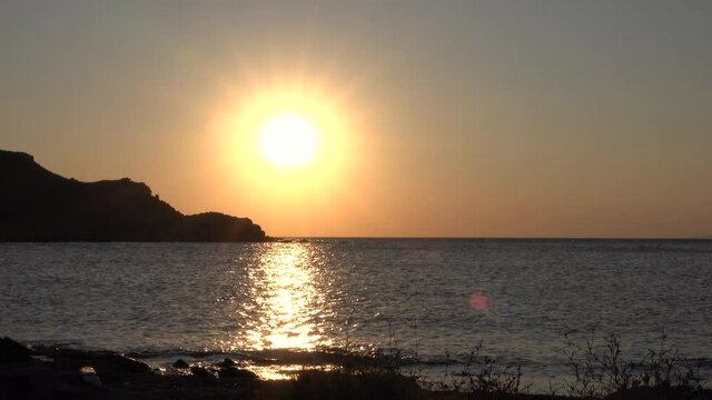 Gokceada, Imbros Island sunset view with mountains sea waves. Kalekoy district in Imbros Canakkale Turkey. 4K motion. sunset on a deserted beach and calmly crashing waves. 