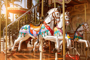 Fototapeta na wymiar Close-up of merry go round carousel horses in sunset