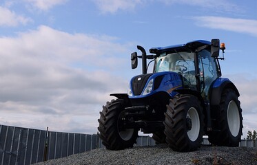 New farm tractor  on a blue colour.
