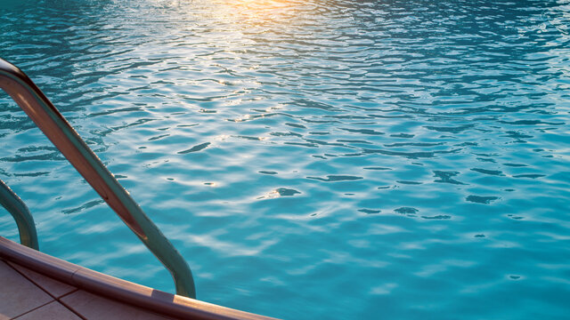 Hintergrund Poolwasser im Sonnenuntergang mit Einstiegsleiter und Fliesen