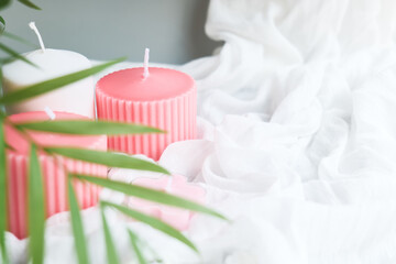 Obraz na płótnie Canvas Romantic wedding dating background with pink candles, flowers and white fabric. Soft selective focus. Aromatherapy, beauty, spa, tenderness concept.