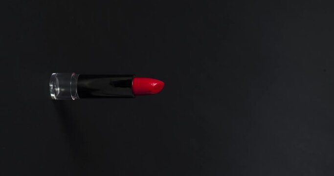 Producto cosm&eacute;tico labial de color rojo con fondos negros y blancos