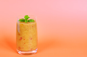 Top view of fresh healthy smoothie in a glass made of peach, banana and berries. Creative concept of healthy detox drink, diet or vegetarian food concept. Copy space.
