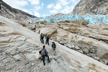 Tourists are climbing rock surface of Jostedal Glacier