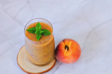 Top view of fresh healthy smoothie in a glass made of peach, banana and berries. Creative concept of healthy detox drink, diet or vegetarian food concept. Copy space.