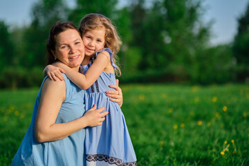 nature scene with family outdoor lifestyle. Mother and little daughter playing together in a park. Happy family concept. Happiness and harmony in family life.