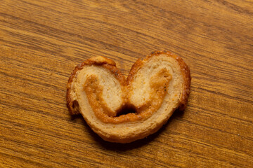 top view of a delicious freshly baked puff pastry ear on a wood colored board
