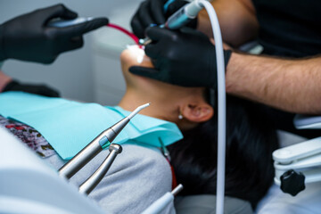 Dentist curing a female patient in the stomatology. Teeth treatment concept. Cropped photo
