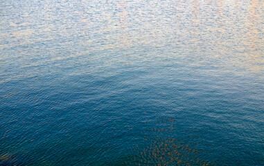 Ripples on the water and reflexes of the sky and clouds at twilight.