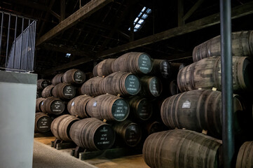 Old porto lodge with rows of oak wooden casks for slow aging of fortified ruby or tawny porto wine in Vila Nova de Gaia, Portugal