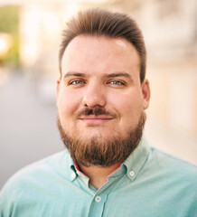 Portrait of a young millennial bearded man on city streets