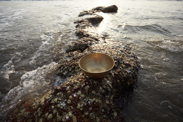 Fototapeta na wymiar Vibration bowl in hands with sea background