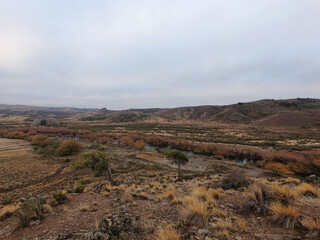 Rural landscape. The field in early morning. Panorama view of the golden valley, yellow grassland and hills in autumn.
