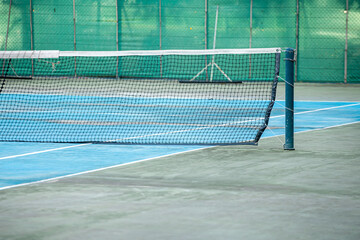 Blue ground tennis court and net , Sports background with tennis concept