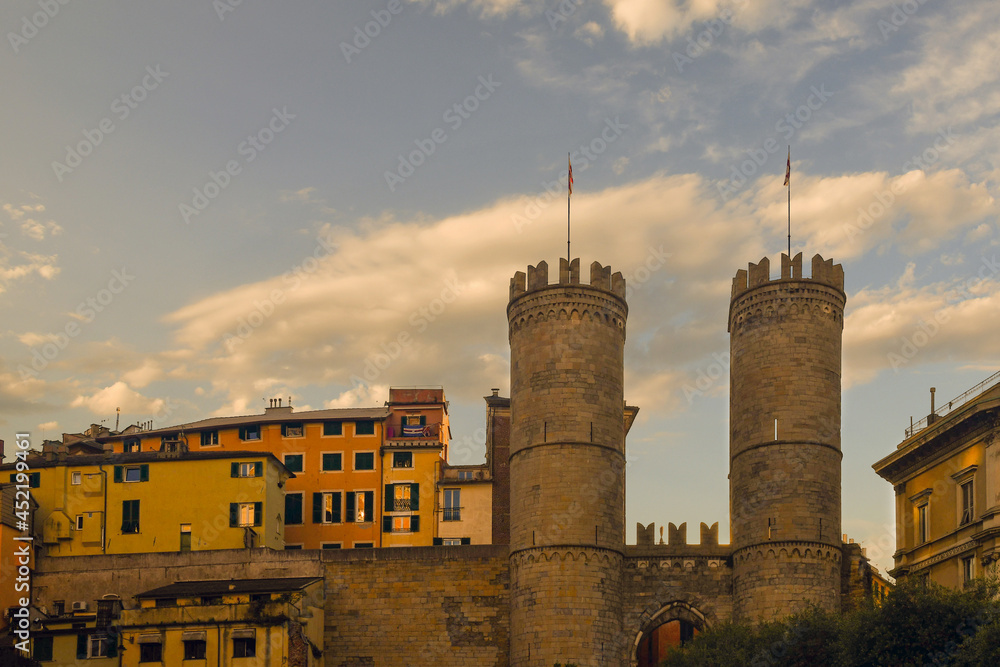 Wall mural Cityscape with the medieval gateway Porta Soprana against sunset sky, Genoa, Liguria, Italy